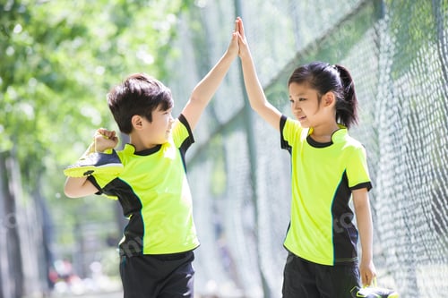 Preview: Happy children in sportswear high fiving