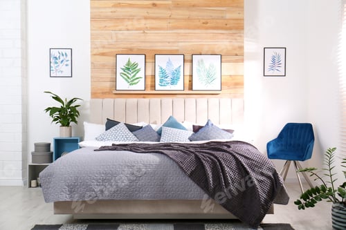 Preview: Stylish room interior with large comfortable bed and beautiful paintings