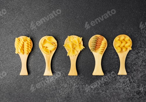 Preview: Different shapes of pasta displayed in wooden scoops on a dark surface