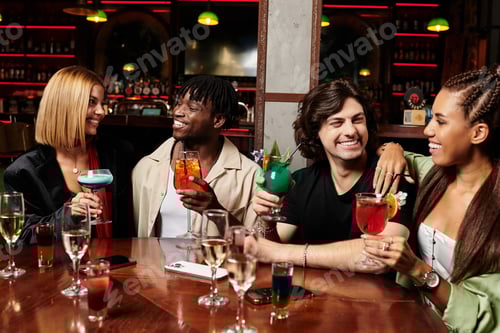 Preview: Young diverse colleagues enjoy cocktails and laughter at a vibrant corporate celebration