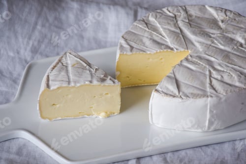 Preview: Brie cheese on a white cutting board