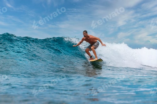 Preview: Shirtless male surfer on a wave at sunny day