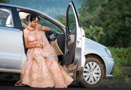 Preview: Beautiful Indian bride sitting in a car.