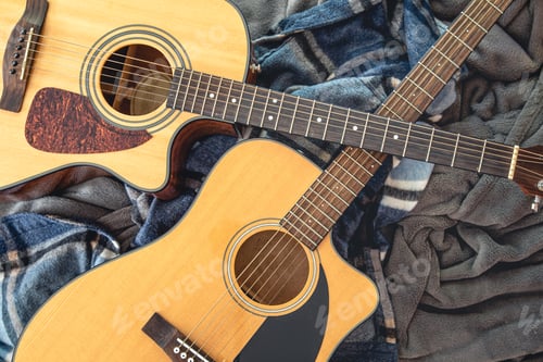 Preview: Two acoustic guitars on a cozy plaid, top view.