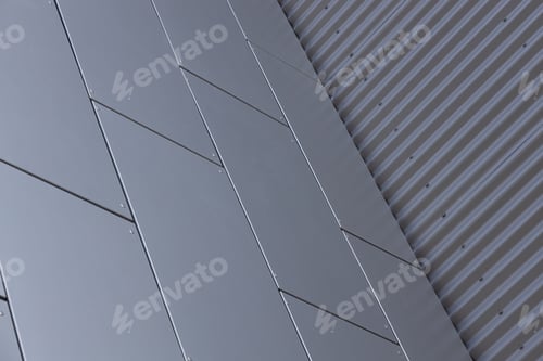 Preview: Bottom view of corner of building - junction of grey smooth tiled wall and metal corrugated wall