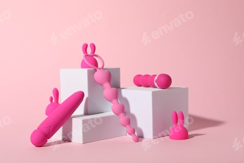 Preview: Composition of pink sex toys with cubes on a pink background