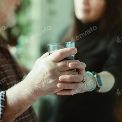 Preview: Closeup of the Caucasian male holding a glass of wine and a Hispanic wife preventing from drinking