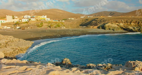 Preview: Spain, Canary Islands, Fuerteventura, sandy volcanic beach in little town Ajuy. Blue ocean waves