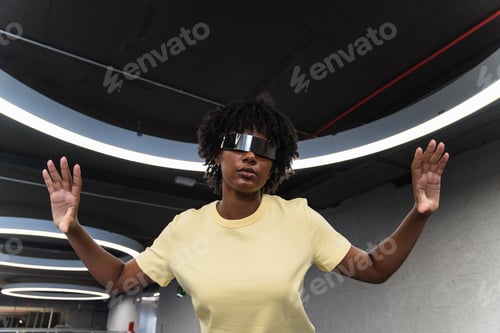 Preview: Young man with futuristic looking through cyber glasses under modern ring lamp