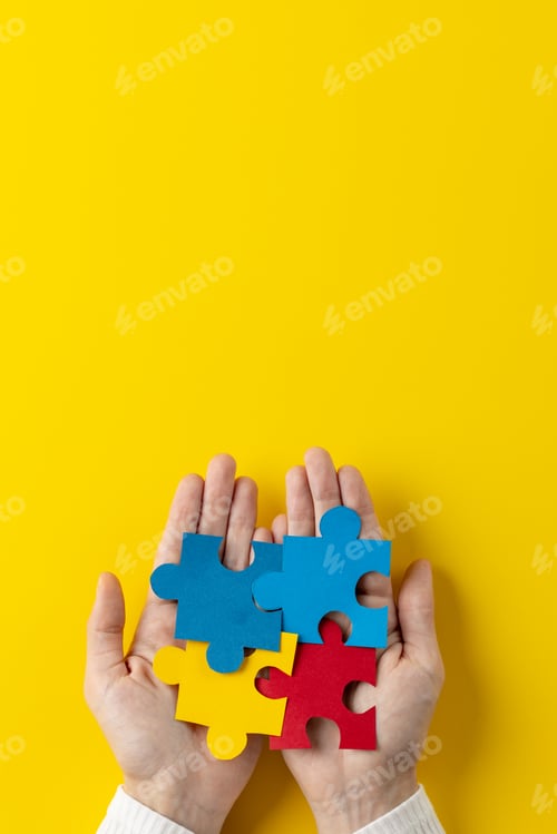 Preview: Vertical composition of hands holding jigsaw puzzle pieces on yellow background with copy space