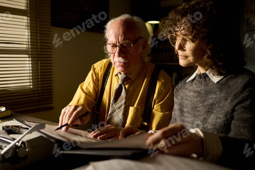 Preview: Senior Caucasian Man Collaborating with Young Adult Caucasian Woman on Paperwork