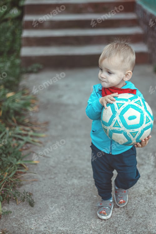 Vista previa: Niño pequeño sosteniendo una pelota.