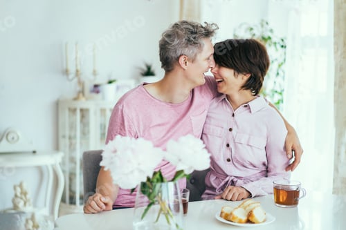 Preview: Laughing Couple in love having fun during breakfast at home kitchen. Hugs and kisses. Happy moments.