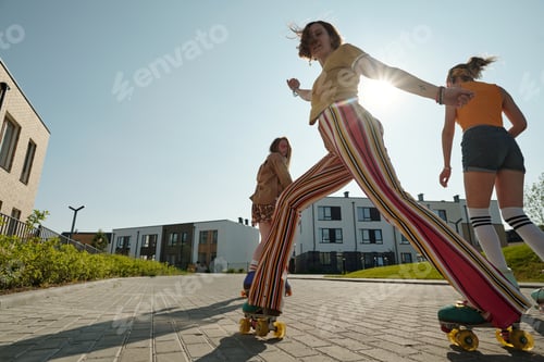 Preview: Happy active girl in casualwear and roller skates skating in the street
