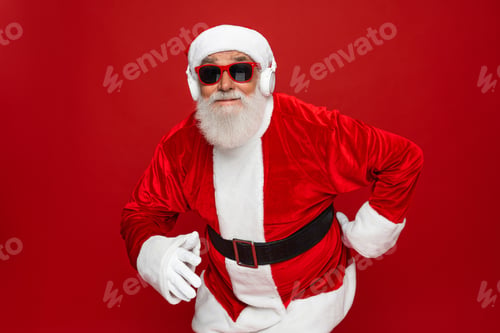 Preview: Crazy santa claus in sunglasses wireless headphone listen music dance party having fun isolated