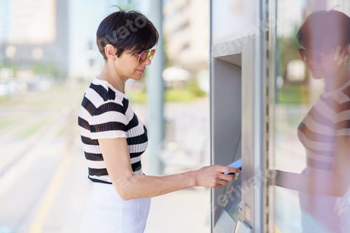 Preview: Focused woman paying for purchase with smartphone