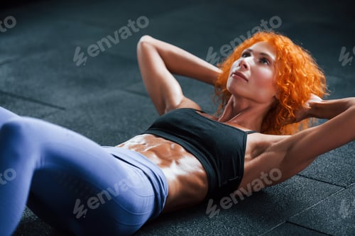 Preview: Sporty redhead girl have fitness day in gym at daytime. Muscular body type