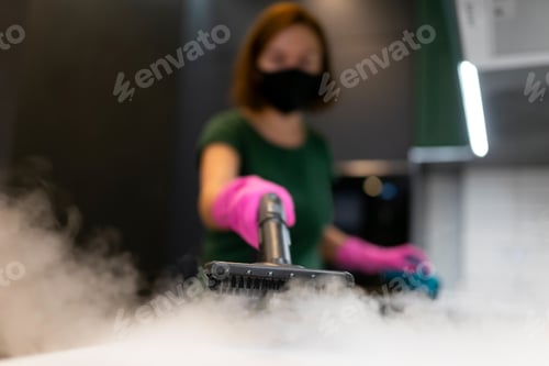 Preview: Woman employee cleaning company blows vapor out of steam generator.