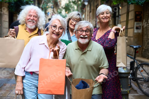 Preview: Happy senior friends enjoying shopping together on city street