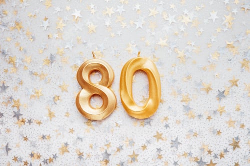 Preview: Number 80 eighty golden celebration birthday candle on Festive Background.