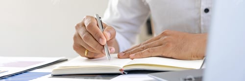 Preview: Businessman holding pen in hand analyzing the graph at desk sales data and economic growth graph cha