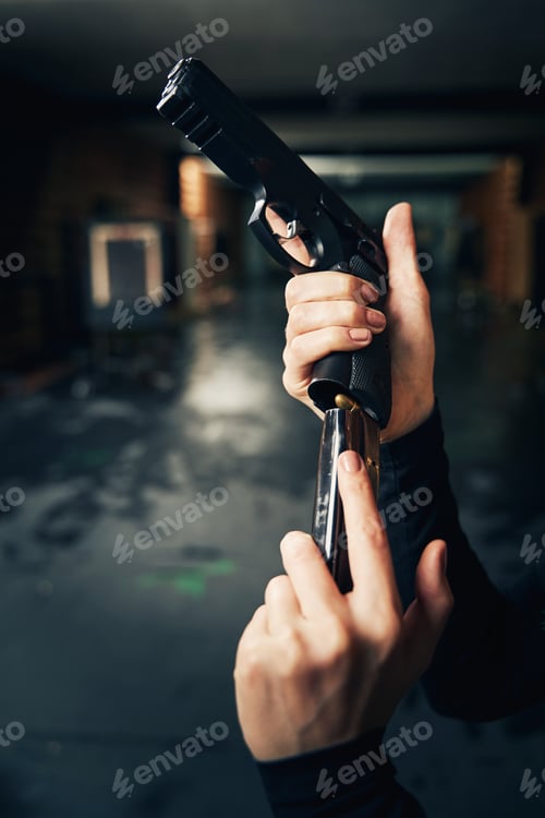 Preview: Woman military loading a pistol before a shooting drill