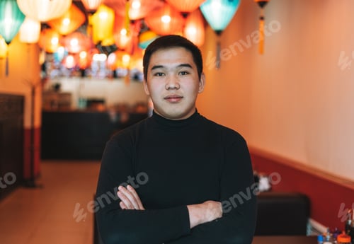 Preview: Handsome young asian man in black clothes in festive chinese vietnamese restaurant