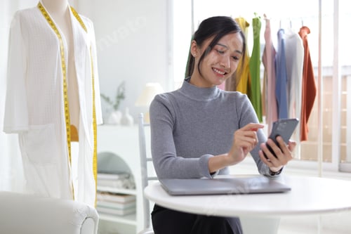 Preview: Young Asian woman, entrepreneur, starting a small business, clothing store.