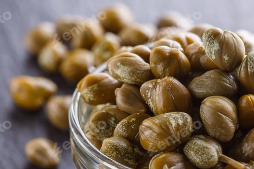 Preview: pickled capers on a dark stone background