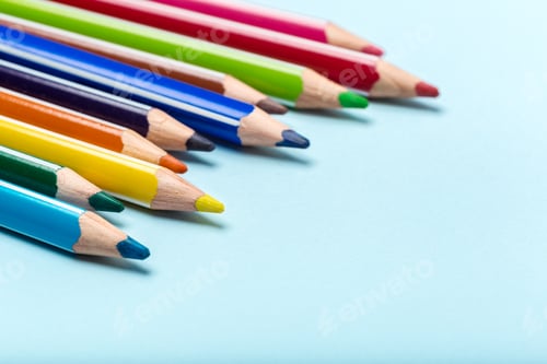 Preview: Colorful pencils lined up on blue background for art and drawing activities
