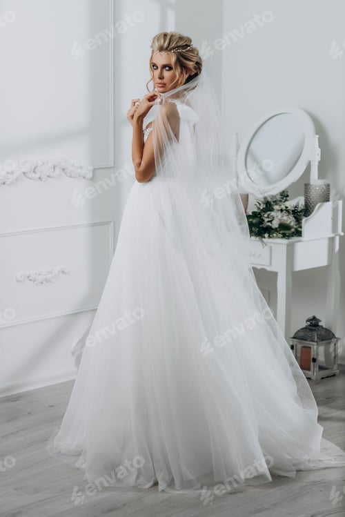 Preview: Beautiful Woman in Elegant Wedding Dress in Studio