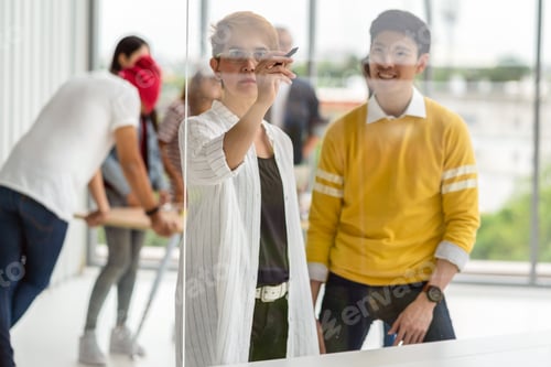 Preview: Senior Asian creative woman hand writing on the millor board over Group Of Asian Business