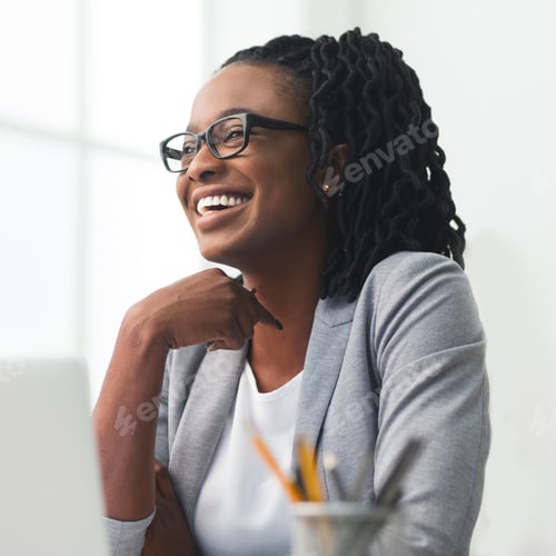 Preview: African American Businesswoman Laughing Sitting Against Window In Office
