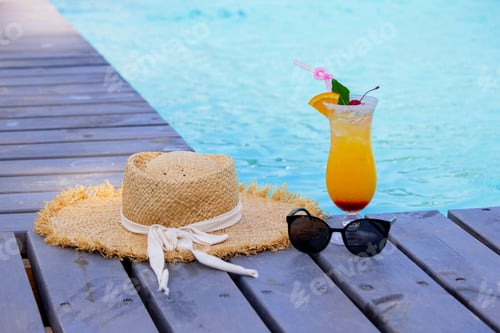 Preview: A nice cocktail, hat and sunglasses by the pool