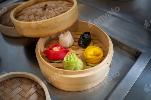 Preview: Colorful steamed dumplings in bamboo steamer on a kitchen surface