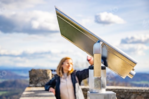 Preview: Woman takes a selfie of city Singen from observation deck with telescope of castle Hochnetwil