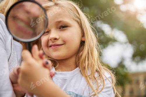 Preview: Woman showing for little girl how work with glass magnifying