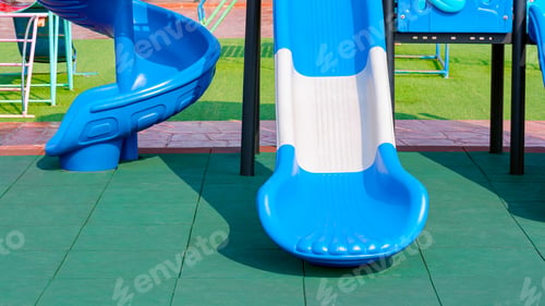 Preview: 2 slides with playground equipment on green EPDM rubber floor with grass and stone tile floor