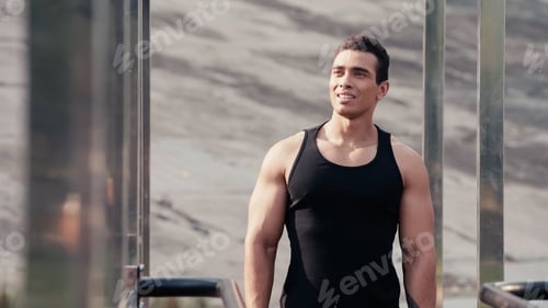 Preview: smiling bi-racial sportsman looking away at outdoors gym on blurred foreground