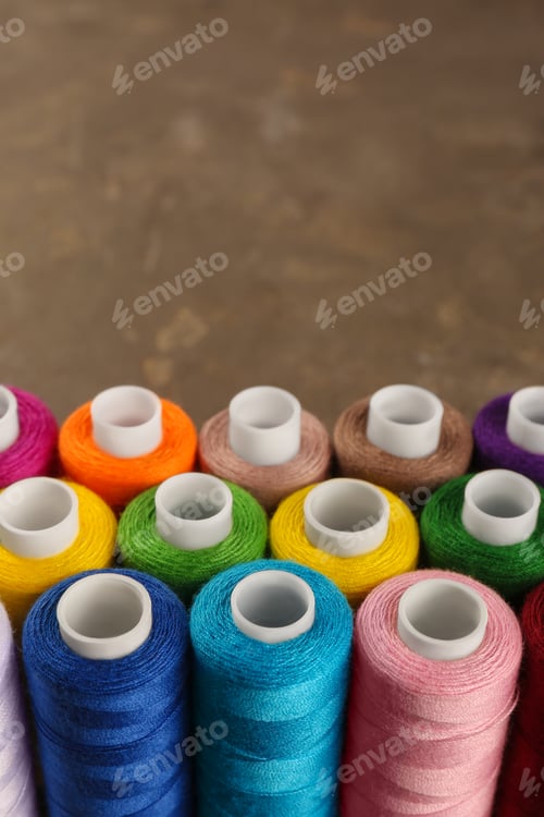 Preview: Set of color sewing threads on grey table