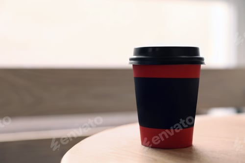 Preview: Hot coffee in takeaway paper cup on wooden table at cafe, space for text