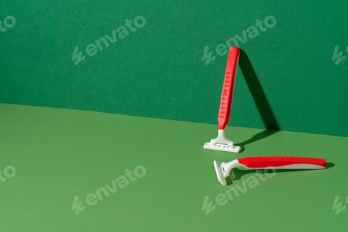 Preview: Disposable razor on green background, studio shot