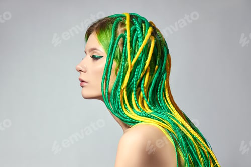 Preview: Portrait of woman with creatively colored hair in green and yellow color. Colorful bright dreadlocks