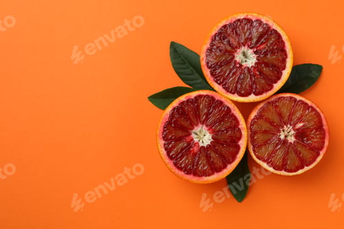 Preview: Red orange halves and leaves on orange background