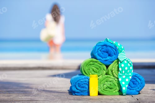 Preview: Beach and summer accessories concept - colorful towels, swimsuit and sunsblock