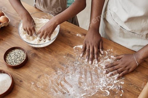 Preview: Black mother and daughter baking together with flour