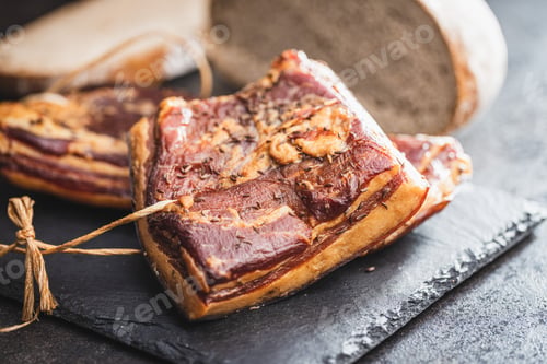 Preview: Whole smoked bacon on cutting board.