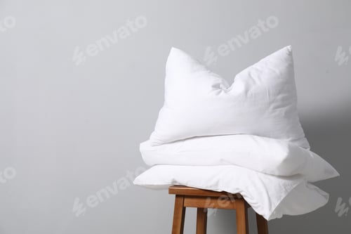 Preview: Soft pillows on chair neal light grey wall, space for text