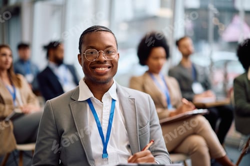 Preview: Happy black entrepreneur attending a business seminar and looking at camera.