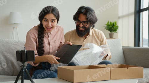 Preview: Couple bloggers customers open package box order online shopping delivery excited happy Arabian man